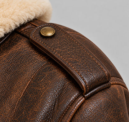 Custom leather pilot jacket shoulder detail without pilot shoulder board, featuring a closed brown leather epaulette secured with a brass button.