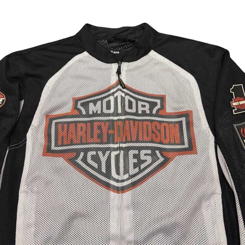 Close-up of the Bar & Shield branding on the white motorcycle jacket.