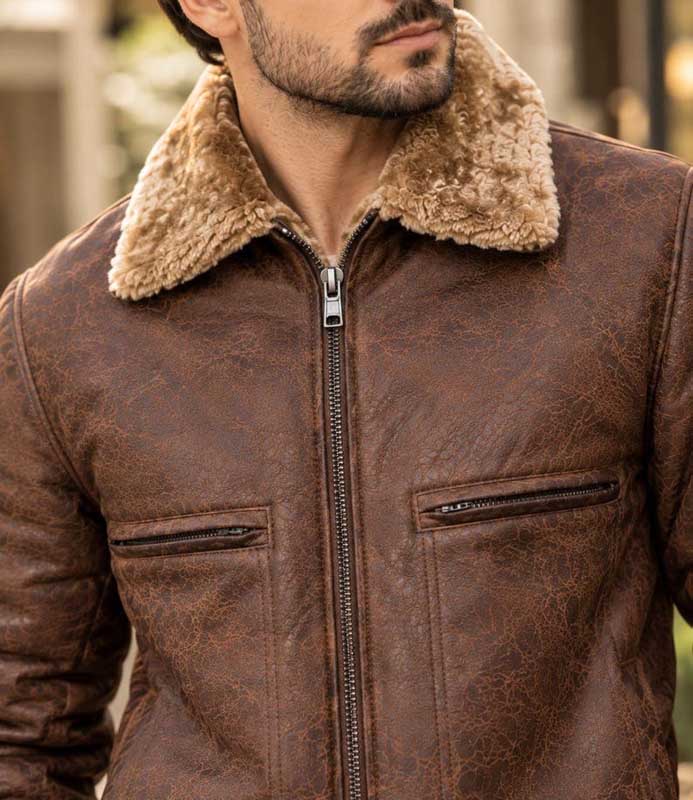 Close-up of shearling-style collar and textured leather on brown bomber jacket
